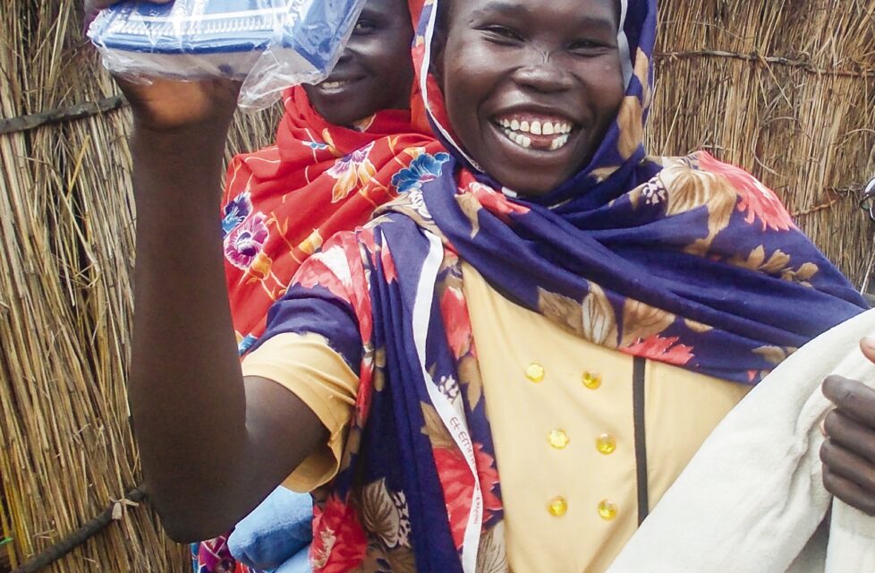 a woman smiles and holds up her new bible